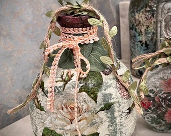 Large Tequila Bottle decopauged with white roses wrapped in green leaves and pink lace ribbon and topped with antique glass knob