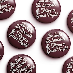 Puede incluir: Un conjunto de siete chapas redondas con un fondo de color burdeos intenso y texto blanco en cursiva que dice: Be Safe Be Smooth & Have a Great Night. Cada chapa presenta un acabado brillante y un diseño tipográfico centrado y uniforme.
