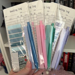 Puede incluir: Un conjunto de juegos de papelería de registro de lectura, cada uno con un registro de lectura, notas adhesivas y un bolígrafo. Los registros de lectura tienen espacio para el título, las fechas de inicio y finalización y una calificación. Los bolígrafos y las notas adhesivas vienen en varios colores pastel.