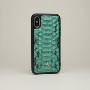 May include: A teal green snakeskin phone case with a black border and a silver letter 'A' logo.