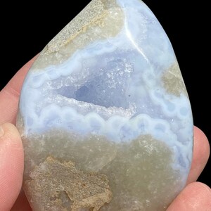 Puede incluir: Una geoda de &aacute;gata azul con una gran cavidad abierta. La geoda es de color azul claro con bandas blancas y grises. La geoda es lisa y pulida.