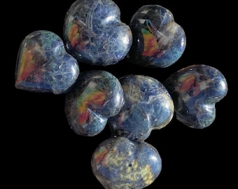 May include: Seven heart-shaped blue kyanite stones with iridescent rainbow colors. The stones are polished and have a smooth, glossy finish.