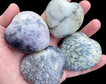 May include: Four heart-shaped polished stones with dendritic agate patterns in shades of white, gray, and purple.