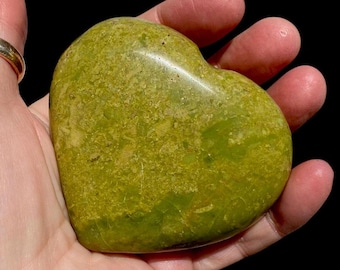 May include: A green heart-shaped polished stone with a mottled pattern.