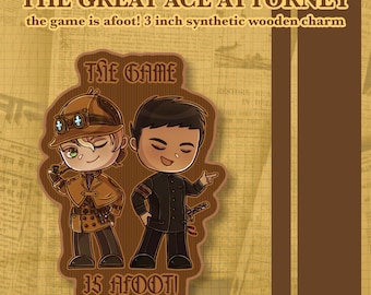 Może przedstawiać: Zawieszka z syntetycznego drewna o wymiarach 7,62 cm przedstawiająca dwie postacie z kreskówek z The Great Ace Attorney. Jedna postać ma na sobie beżowy strój detektywa z kapeluszem i goglami, a druga ciemny mundur. Napis głosi The Game Is Afoot.