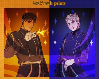 Może przedstawiać: Dwie odbitki artystyczne Fullmetal Alchemist o wymiarach 12,7 x 17,8 cm przedstawiające Roya Mustanga na pomarańczowym tle z płomieniami oraz Rizę Hawkeye na niebieskim tle z gwiazdami. Postacie noszą ciemne mundury wojskowe ze złotymi detalami.