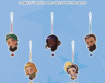 Może przedstawiać: PKMN SV PHONE CHARMS, roughly 1.5" acrylic charms with a colorful star accent. Pięć akrylowych zawieszek w stylu chibi ze smyczami, przedstawiających różne kolory włosów i stroje, z małymi gwiazdkami przymocowanymi do każdej.