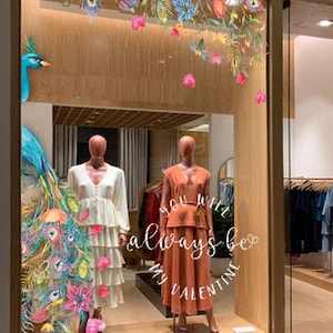 The Women's dress store, boutique storefront, showcase, watercolour print floral, flowers, paradise bird, peacocks, blue, pink, violet, purple fur.