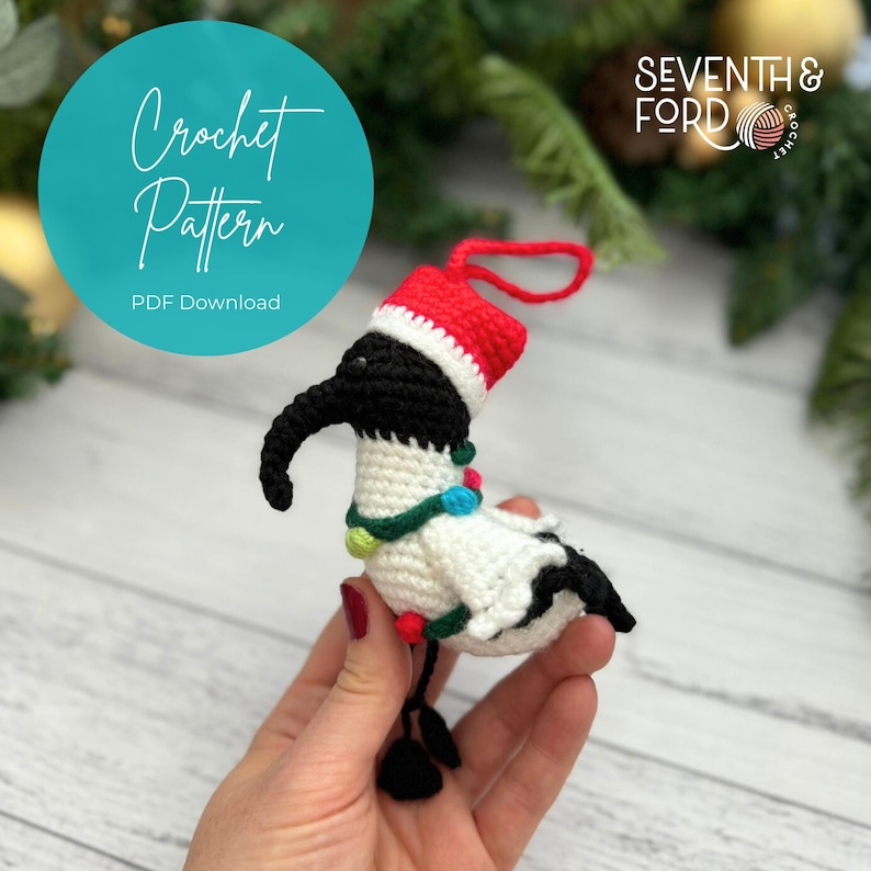 A crochet Ibis bird wearing a santa hat and a christmas light garden sits on a toy rubbish bin in reference to the Australian term for the bird, bin chicken