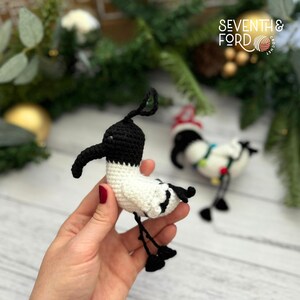A crochet Ibis bird wearing a santa hat and a christmas light garden. Also known by the Australian term for the bird, bin chicken
