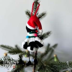 A crochet Ibis bird wearing a santa hat and a christmas light garden. Also known by the Australian term for the bird, bin chicken