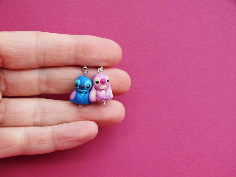 May include: A pair of blue and pink Stitch character earrings. The earrings are made of polymer clay and feature the iconic Stitch character from the Disney movie Lilo & Stitch.