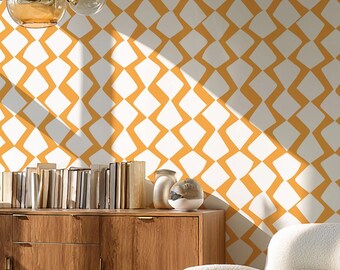 May include: A modern living room featuring a white and orange geometric patterned wallpaper. The room includes a wooden cabinet, a gold side table, a white armchair, and a decorative light fixture. The room is well-lit with natural light.