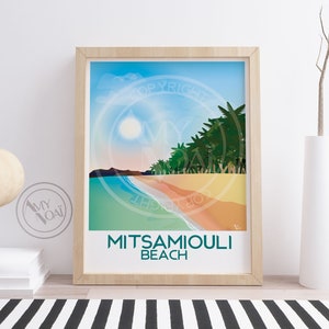 May include: A framed art print featuring a beach scene with the text "MITSAMIOULI BEACH." The artwork depicts a sunny beach with palm trees, a blue sky, and a colorful shoreline. The frame is light-colored wood.