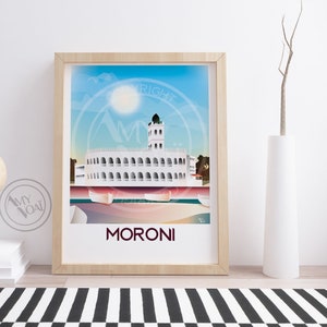 May include: A framed art print featuring a stylized illustration of Moroni, with a white building and a tower under a blue sky. The print is in a light wood frame and includes the text "MORONI".
