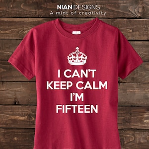 May include: Red t-shirt with a white crown and the text "I can't keep calm I'm fifteen".
