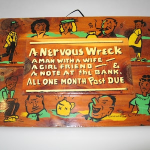 May include: A wooden sign with a humorous saying: "A Nervous Wreck - A man with a wife, a girl friend, a note at the bank, all one month past due". The sign is painted with cartoon figures and has a rustic, vintage look.