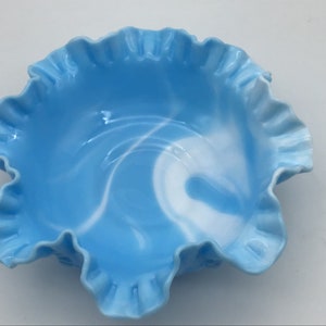 May include: A blue and white swirl glass bowl with a ruffled edge.