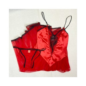 May include: Red satin and sheer lace lingerie set with black trim. The set includes a chemise and a matching panty.