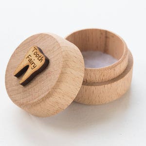 Könnte beinhalten: Eine kleine Holzkiste mit einem zahnförmigen Deckel. Der Deckel ist mit den Worten "Tooth Fairy" graviert.