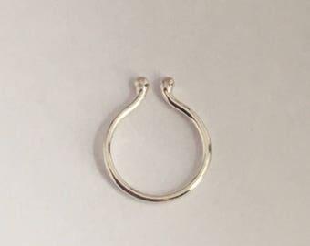 Puede incluir: Un aro para la nariz de plata con un diseño simple y redondeado.