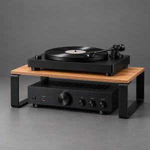 May include: A black turntable sits on a wooden shelf with black metal legs. Below the shelf, a black audio amplifier with a central volume knob, several smaller control dials, and a headphone jack is positioned on the surface.