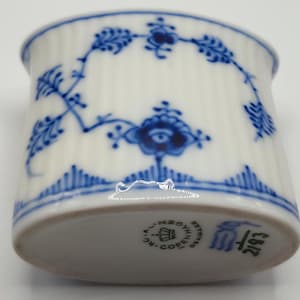 Może przedstawiać: Biały porcelanowy kubek z niebieskim kwiatowym wzorem. Kubek ma pionowe żłobienia i niebieski kwiatowy wzór na górze i na dole. Spód kubka ma pieczęć z tekstem i numerem 2193.