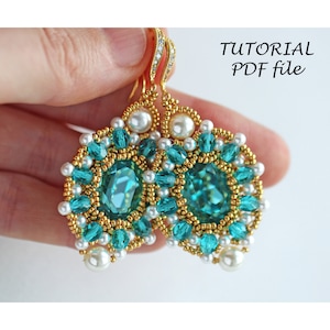 Op de afbeelding: Een paar gouden oorbellen met turquoise en witte kralen. De oorbellen hebben de vorm van een bloem met een grote turquoise edelsteen in het midden. De oorbellen hangen aan een gouden haak.