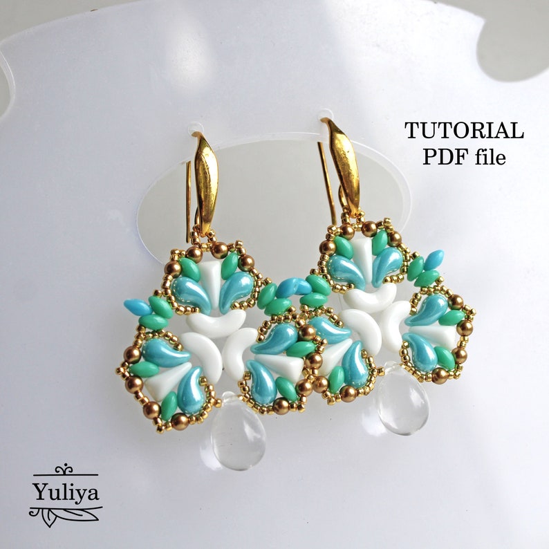 May include: A pair of gold earrings with a white and blue beaded design. The earrings are shaped like a flower with a teardrop-shaped crystal hanging from the bottom. The image includes the text "TUTORIAL PDF file".