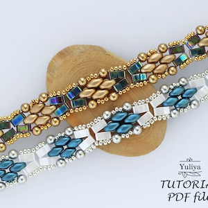 Op de afbeelding: Twee kralenarmbanden, een met gouden en iriserende blauwe kralen, de andere met zilveren, witte en blauwe kralen. De armbanden liggen op een houten oppervlak. De tekst "Yuliya TUTORIAL PDF file" staat onderaan de afbeelding.