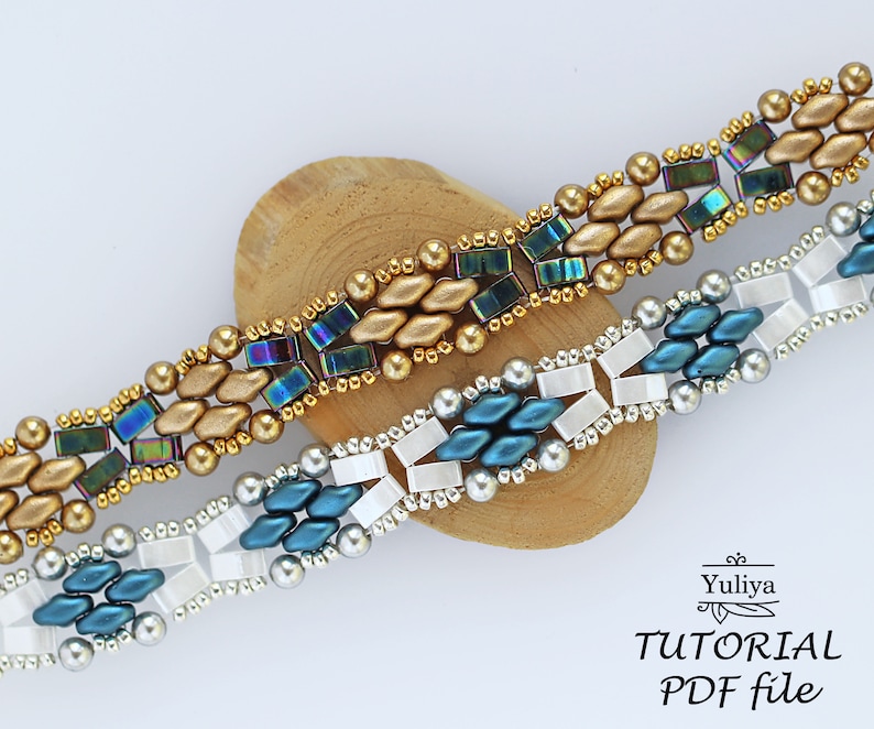 Op de afbeelding: Twee kralenarmbanden, een met gouden en iriserende blauwe kralen, de andere met zilveren, witte en blauwe kralen. De armbanden liggen op een houten oppervlak. De tekst "Yuliya TUTORIAL PDF file" staat onderaan de afbeelding.