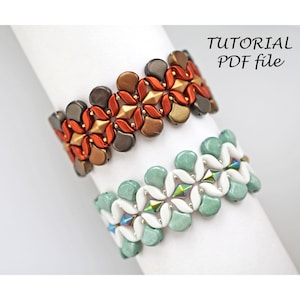 May include: Two beaded bracelets, one with orange, brown, and gold beads, and the other with white, green, and iridescent beads. The bracelets are on a white surface with the text "TUTORIAL PDF file" above them.