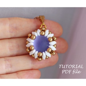 Może przedstawiać: Fioletowy wisiorek z koralików ze złotym łańcuszkiem i białymi i złotymi koralikami. Wisiorek ma kształt kwiatu z okrągłym środkiem.  "TUTORIAL PDF file" jest napisane białym kolorem na czarnym tle.