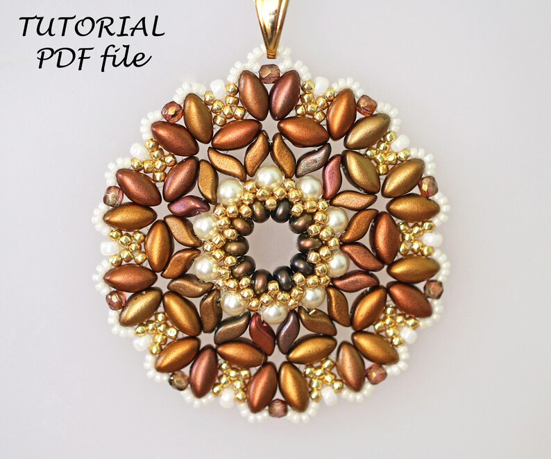 May include: A gold, brown, and white beaded pendant with a circular design. The pendant is made with seed beads and pearls.