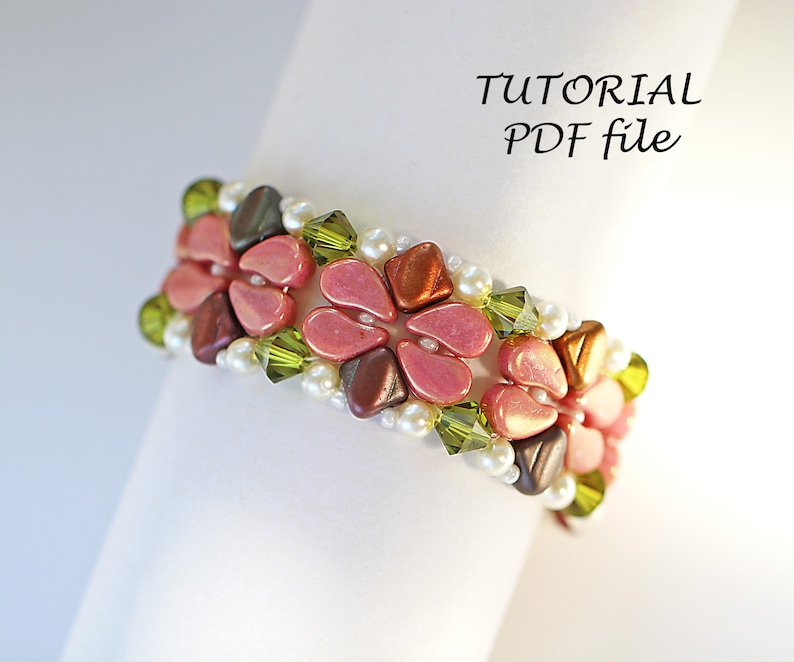 May include: A beaded bracelet with pink, brown, and green beads in a floral pattern. The bracelet is on a white surface with the text "TUTORIAL PDF file".