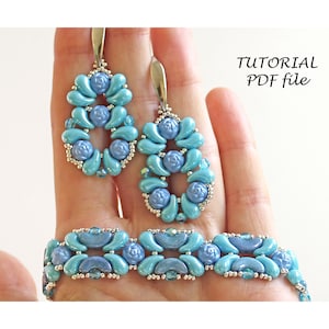 May include: A turquoise and blue beaded bracelet and earrings set. The earrings are teardrop shaped and the bracelet is a delicate chain with a repeating pattern.