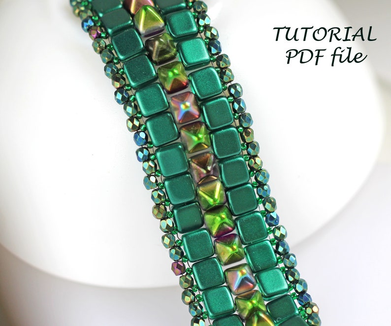 May include: A green and iridescent beaded bracelet with a square and pyramid bead pattern. The bracelet is on a white surface with the text "TUTORIAL PDF file".