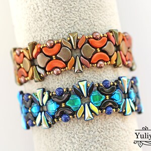 K&ouml;nnte beinhalten: Zwei Perlenarmb&auml;nder mit geometrischen Mustern. Das obere Armband besteht aus orangefarbenen, braunen und goldenen Perlen, w&auml;hrend das untere Armband aus blauen, gr&uuml;nen und schwarzen Perlen besteht.