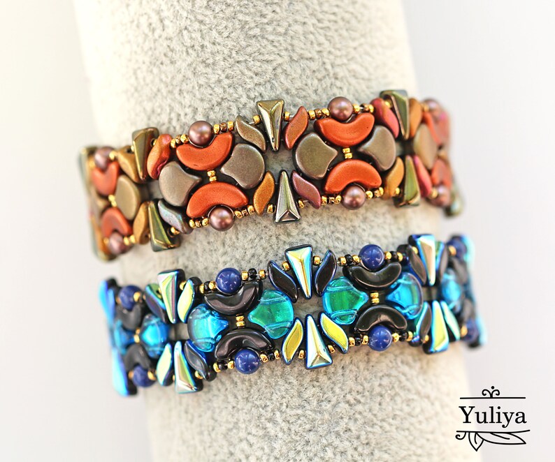 K&ouml;nnte beinhalten: Zwei Perlenarmb&auml;nder mit geometrischen Mustern. Das obere Armband besteht aus orangefarbenen, braunen und goldenen Perlen, w&auml;hrend das untere Armband aus blauen, gr&uuml;nen und schwarzen Perlen besteht.