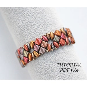 Könnte beinhalten: Ein Armband aus Perlen mit einem geometrischen Muster in Braun-, Gold- und Rottönen. Das Armband ist aus kleinen, facettierten Perlen gefertigt und hat ein schlichtes, elegantes Design. Das Bild enthält den Text "TUTORIAL PDF file".