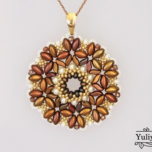 May include: A gold pendant necklace with a round, beaded design. The beads are in shades of brown, gold, and white, creating a floral pattern.