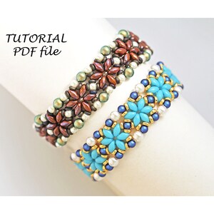 May include: Two beaded bracelets with a flower pattern. The top bracelet is brown, gold, and white. The bottom bracelet is blue, gold, and white.