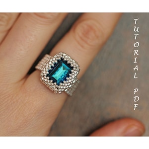 May include: A silver beaded ring with a large, rectangular, teal blue gemstone.
