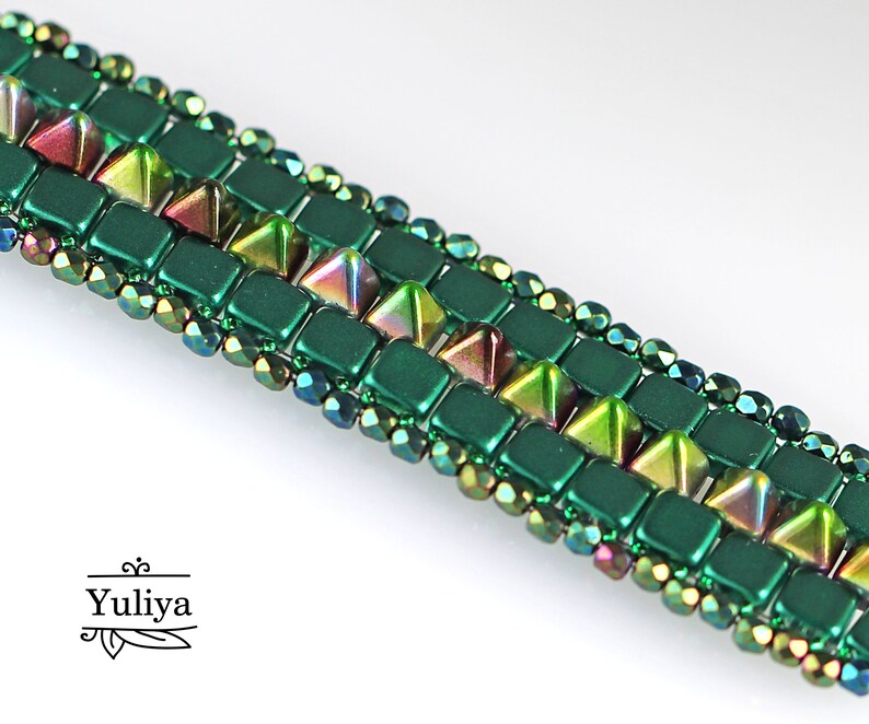 May include: A green and iridescent beaded bracelet with a geometric pattern. The bracelet features square and triangular beads.