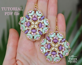 May include: A pair of gold earrings with a geometric design made with beads in shades of pink, green, and purple. The earrings are handmade and have a delicate, intricate design.