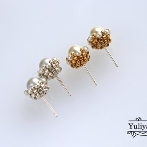 May include: A pair of pearl earrings with gold and silver beading. The earrings are on a white background.