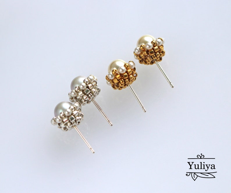 May include: A pair of pearl earrings with gold and silver beading. The earrings are on a white background.