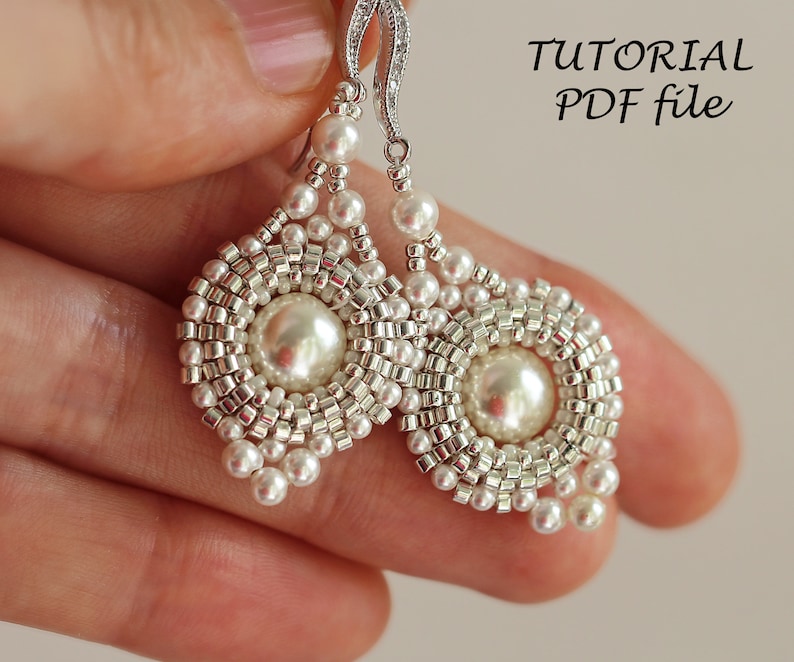 Może przedstawiać: Para srebrnych kolczyk&oacute;w z białymi perłami i koralikowym wzorem. Kolczyki mają dużą perłę w środku każdego kolczyka. Kolczyki wiszą na srebrnym haczyku. Obraz zawiera tekst "TUTORIAL PDF file".