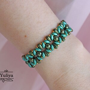 Peut inclure: Un bracelet en perles vertes et dor&eacute;es avec un motif g&eacute;om&eacute;trique. Le bracelet est compos&eacute; de petites perles en forme de goutte.