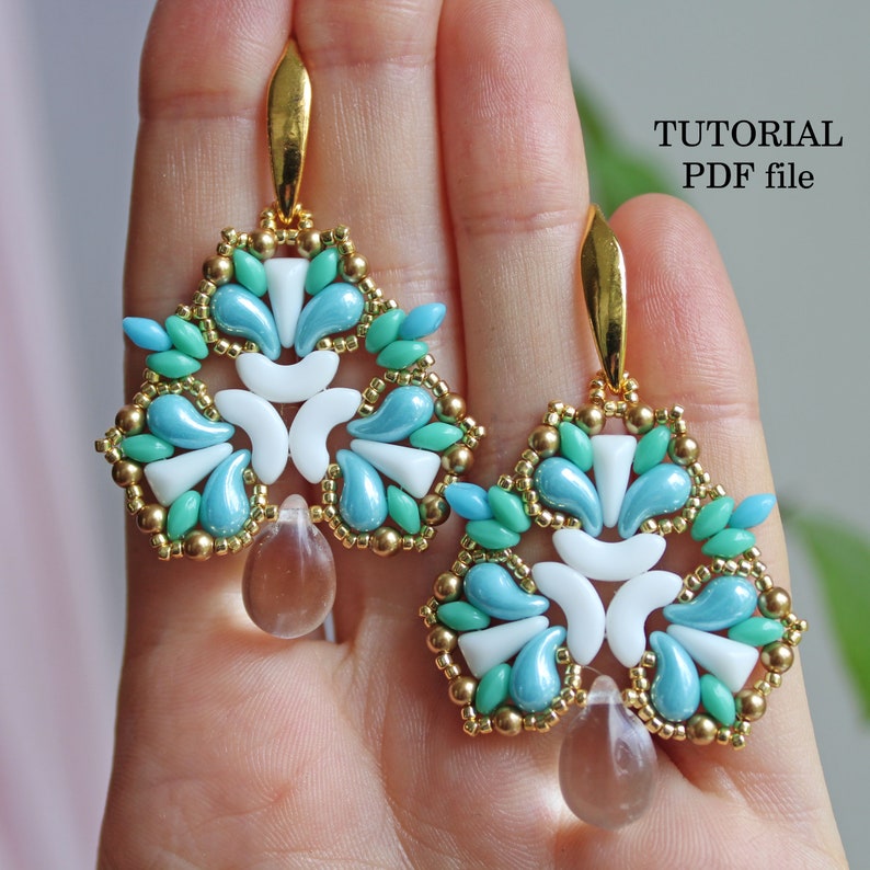 May include: A pair of turquoise, white, and gold beaded earrings with a teardrop-shaped crystal dangle.  The earrings are in the shape of a stylized flower.  The image includes the text "TUTORIAL PDF file".